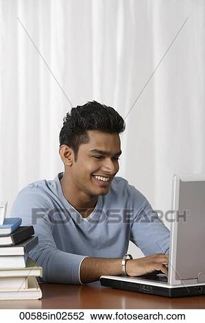 young man using laptop at his desk View Large Photo Image Stock Image - young man using laptop at his desk. Fotosearch
