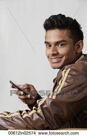 Picture - young man using mobile phone. Fotosearch