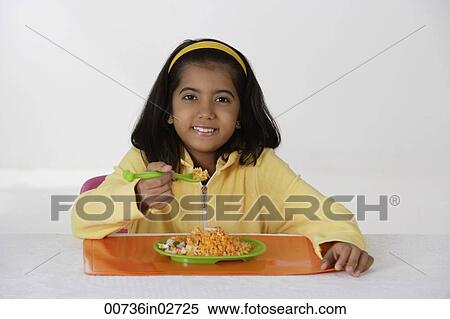 Stock Photography - Girl eating briyani rice. Fotosearch