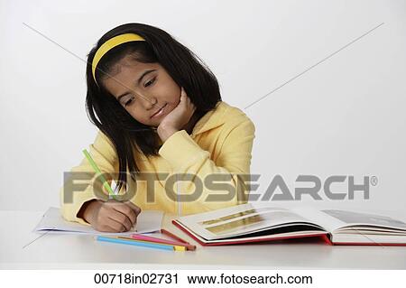Stock Image - Girl working with color pencils and book. Fotosearch