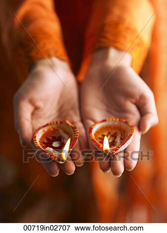 Stock Photo - Hands holding oil lamps. Fotosearch