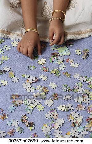 Hands of little girl working on puzzle View Large Photo Image Stock Photo - Hands of little girl working on puzzle. Fotosearch