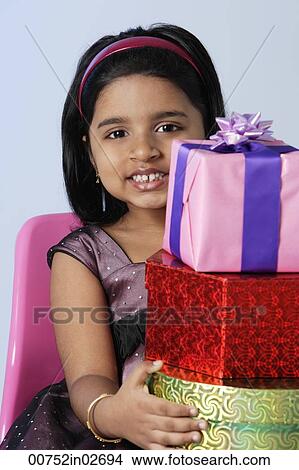 Picture - Little girl holding gifts. Fotosearch
