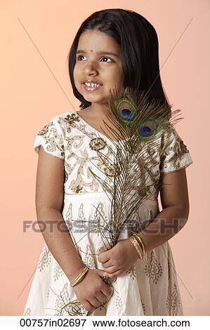 Stock Photo - Little girl wearing traditional Indian clothing holding peacock feathers. Fotosearch