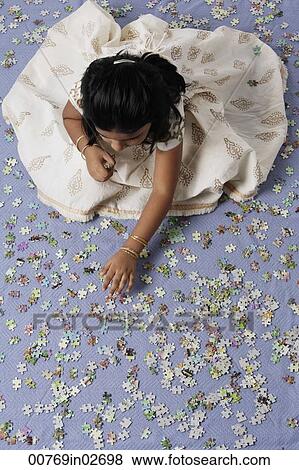 Stock Photo - Little girl working on a puzzle. Fotosearch