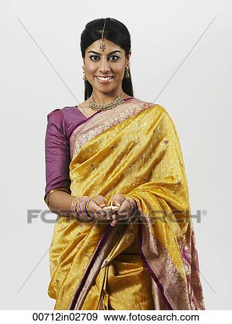 Stock Photo - woman with cupped hands holding oil lamp. Fotosearch