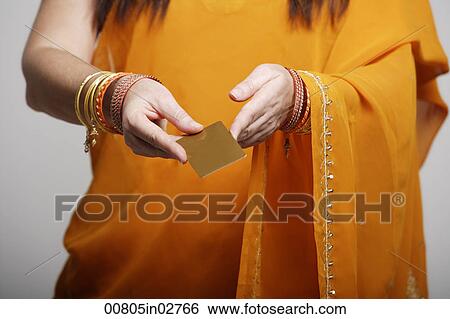Stock Photograph - Cropped shot of woman wearing sari, holding credit card. Fotosearch