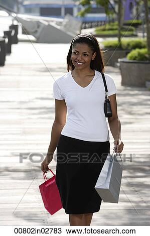 woman walking outside holding shopping bags View Large Photo Image Stock Image - woman walking outside holding shopping bags. Fotosearch