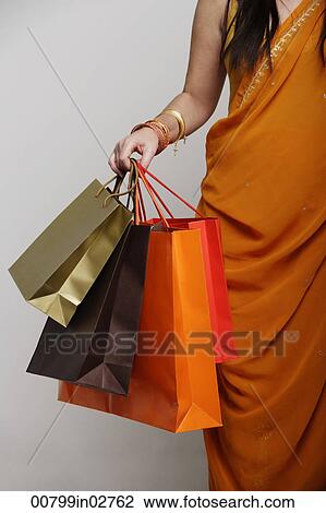 Woman wearing sari holding shopping bags View Large Photo Image Stock Image - Woman wearing sari holding shopping bags. Fotosearch