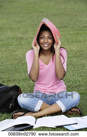 Young woman covering her head with a folder View Large Photo Image Stock Image - Young woman covering her head with a folder. Fotosearch