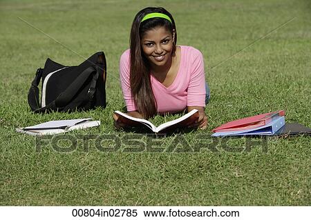 young woman laying on grass studying View Large Photo Image Stock Photography - young woman laying on grass studying. Fotosearch