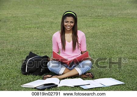 young woman sitting on the grass studying View Large Photo Image Stock Image - young woman sitting on the grass studying. Fotosearch