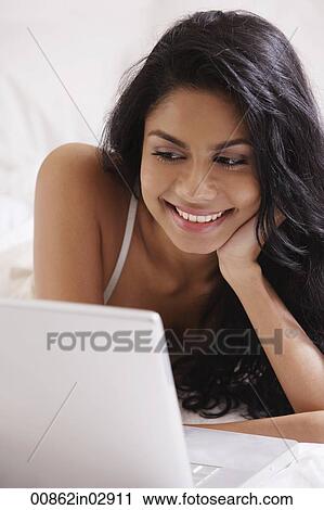 Stock Image - Close up of Indian woman looking at laptop computer. Fotosearch