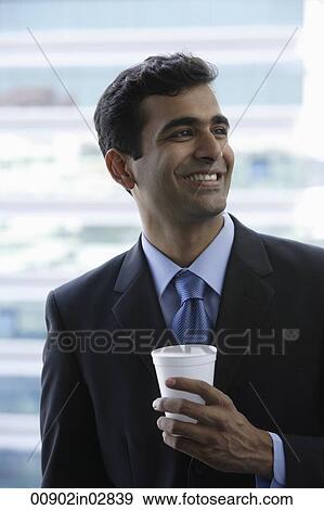 Head shot of Indian businessman holding cup and smiling. View Large Photo Image Stock Photo - Head shot of Indian businessman holding cup and smiling.. Fotosearch