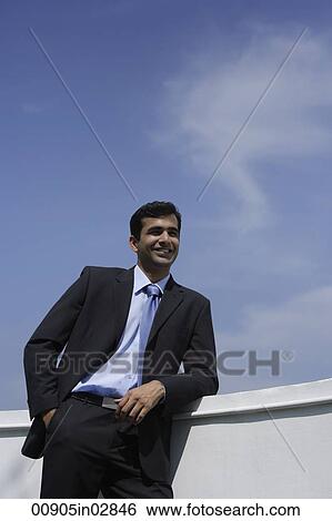 Indian businessman leaning on balcony. View Large Photo Image Stock Photograph - Indian businessman leaning on balcony.. Fotosearch