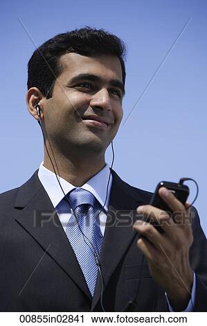 Indian businessman listening to music outside. View Large Photo Image Stock Image - Indian businessman listening to music outside.. Fotosearch