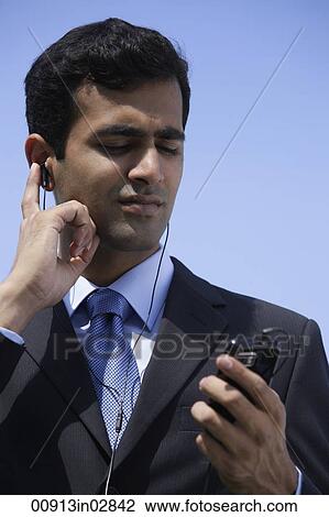 Indian businessman listening to music, outside. View Large Photo Image Stock Image - Indian businessman listening to music, outside.. Fotosearch