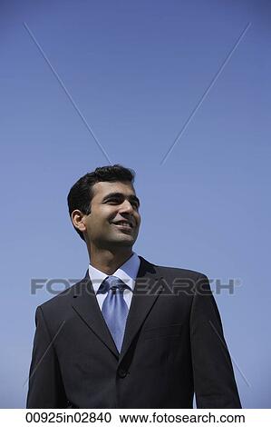 Stock Image - Indian businessman smiling outside.. Fotosearch