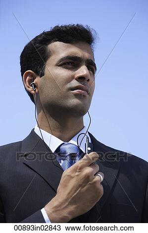 Stock Image - Indian businessman using handsfree device.. Fotosearch