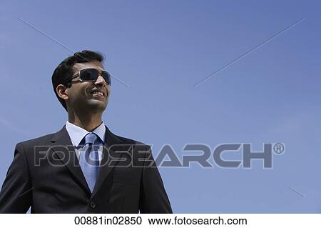 Indian businessman wearing sunglasses and smiling outside. View Large Photo Image Stock Image - Indian businessman wearing sunglasses and smiling outside.. Fotosearch