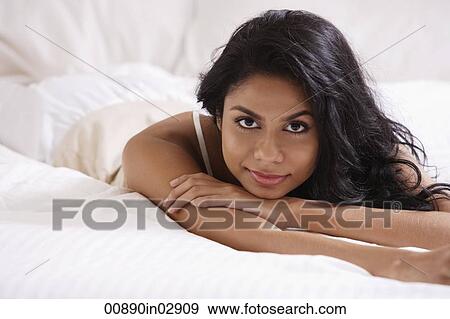 Indian woman laying on bed relaxing View Large Photo Image Stock Photo - Indian woman laying on bed relaxing. Fotosearch
