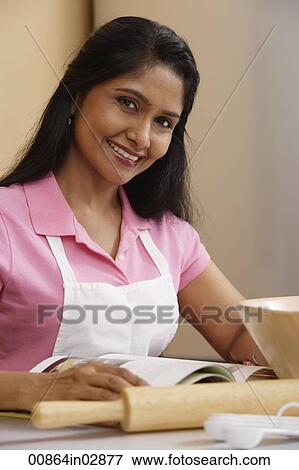 Indian woman preparing food in the kitchen View Large Photo Image Stock Photo - Indian woman preparing food in the kitchen. Fotosearch