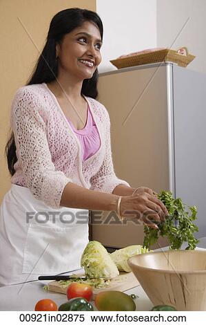 Indian woman preparing food in the kitchen View Large Photo Image Stock Photography - Indian woman preparing food in the kitchen. Fotosearch