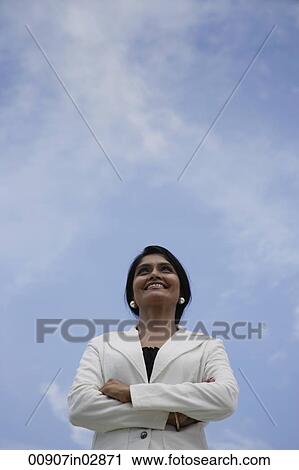 Indian woman smiling and looking up with blue sky background View Large Photo Image Stock Image - Indian woman smiling and looking up with blue sky background. Fotosearch