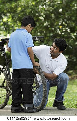 Father and son fixing bike together View Large Photo Image Picture - Father and son fixing bike together. Fotosearch