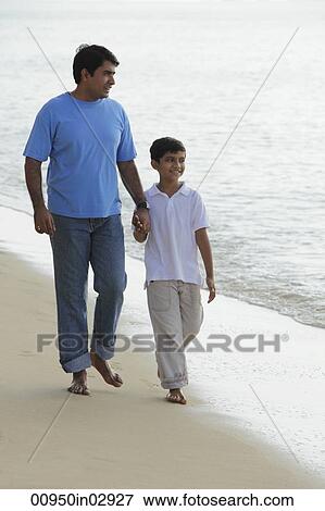 Father and son holding hands and walking down the beach. View Large Photo Image Stock Photo - Father and son holding hands and walking down the beach.. Fotosearch