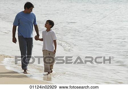 Father and son holding hands and walking on beach View Large Photo Image Stock Photo - Father and son holding hands and walking on beach. Fotosearch
