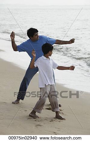 Father and son throwing rocks into the water View Large Photo Image Stock Image - Father and son throwing rocks into the water. Fotosearch