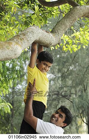 Father helping young boy jump down from tree View Large Photo Image Stock Photography - Father helping young boy jump down from tree. Fotosearch