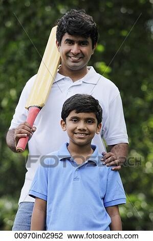 Father holding cricket bat with son View Large Photo Image Stock Image - Father holding cricket bat with son. Fotosearch