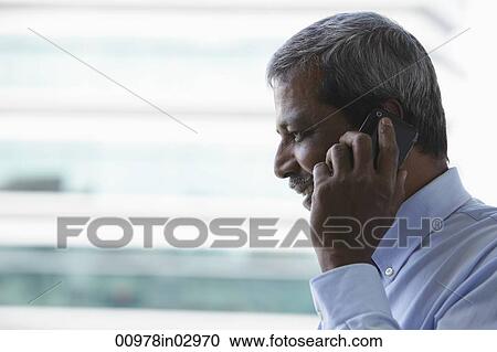 Head shot of mature Indian man talking on phone View Large Photo Image Stock Image - Head shot of mature Indian man talking on phone. Fotosearch