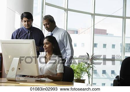 Indian business people looking at a computer View Large Photo Image Stock Image - Indian business people looking at a computer. Fotosearch