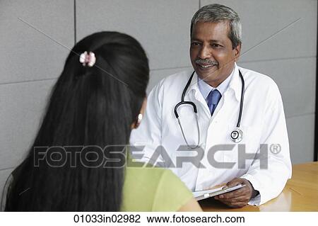 Indian doctor talking to female patient View Large Photo Image Stock Image - Indian doctor talking to female patient. Fotosearch