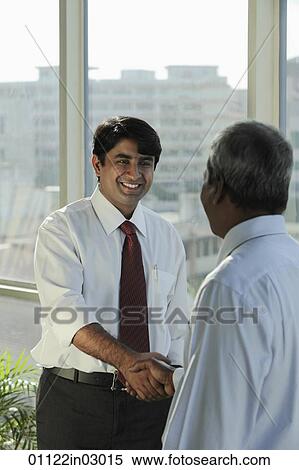 Indian man shaking hands and smiling View Large Photo Image Stock Photography - Indian man shaking hands and smiling. Fotosearch