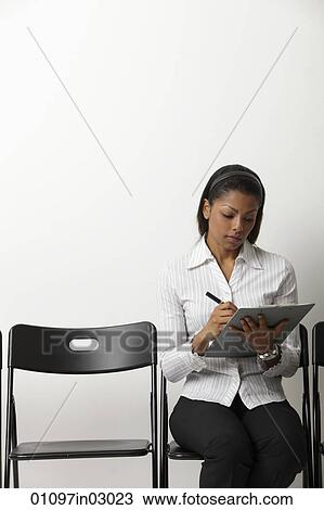 Indian woman fills out form in waiting room View Large Photo Image Stock Image - Indian woman fills out form in waiting room. Fotosearch