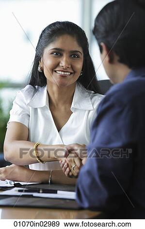 Indian woman shaking hands with male colleague View Large Photo Image Stock Photo - Indian woman shaking hands with male colleague. Fotosearch