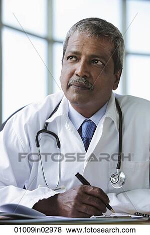 Portrait of Indian doctor thinking and writing View Large Photo Image Stock Photo - Portrait of Indian doctor thinking and writing. Fotosearch