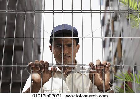 Security guard holding fence and looking stern View Large Photo Image Stock Image - Security guard holding fence and looking stern. Fotosearch