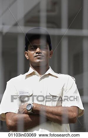 Security guard looking from behind fence View Large Photo Image Stock Photo - Security guard looking from behind fence. Fotosearch