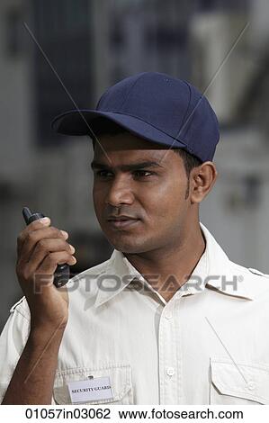 Security guard talking into walkie talkie View Large Photo Image Stock Image - Security guard talking into walkie talkie. Fotosearch