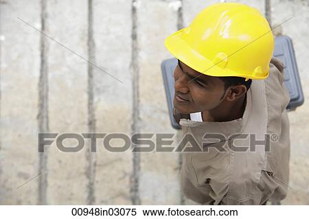 Stock Photography - Top view of man wearing construction hat and walking. Fotosearch