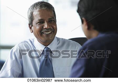 Two businessmen smiling at each other View Large Photo Image Stock Photo - Two businessmen smiling at each other. Fotosearch