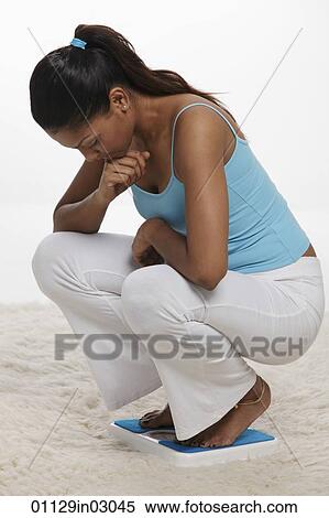 woman bending down looking at scale View Large Photo Image Stock Photography - woman bending down looking at scale. Fotosearch