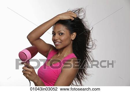 woman blow drying her long hair and smiling View Large Photo Image Stock Image - woman blow drying her long hair and smiling. Fotosearch