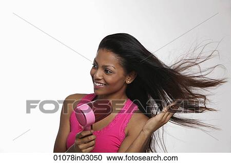woman blow drying her long hair and smiling View Large Photo Image Stock Image - woman blow drying her long hair and smiling. Fotosearch