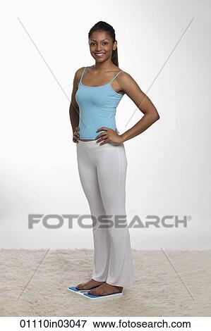 Woman standing on scale with hands on her hips View Large Photo Image Stock Photo - Woman standing on scale with hands on her hips. Fotosearch